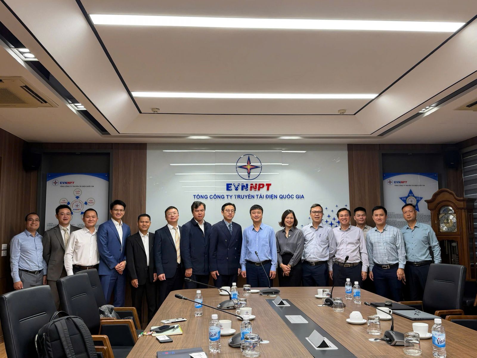 A group of people standing in a meeting roomAI-generated content may be incorrect.